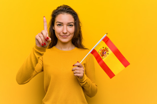 flyinghelpline-young-woman-holding-spanish-flag-showing-number-one-with-finger_1187-56582